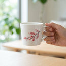 [MUG (CUP)] CHERRY BLOSSOMS (WHITE) | COLOR & DESIGN CHANGE | MINO WARES | MARUMO TAKAGI｜使用イメージ（演出・手持ち）※手作りのため色・風合いは一点ごとに異なります